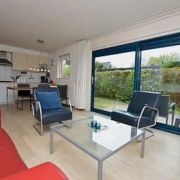 Offener Wohnbereich im Ferienhaus De Parel 192, De Dennen, Texel mit Zugang zum Garten und einer voll ausgestatteten Kueche.