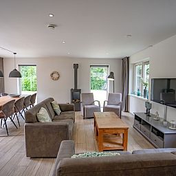 Gemuetliches Wohnzimmer des Ferienhauses de Parel 152 in De Dennen, Texel mit Blick auf den Garten.