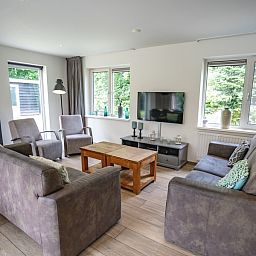 Gemuetliche Sitzecke im Ferienhaus de Parel 152, De Dennen, Texel mit grossen Fenstern.