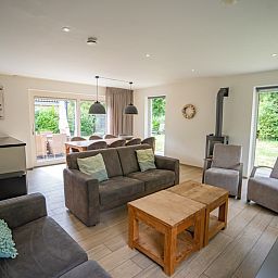 Offener Wohnbereich im Ferienhaus de Parel 152, Texel mit moderner Einrichtung und Gartenblick.