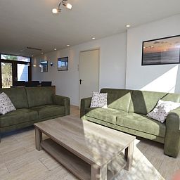 Geraeumiges Interieur des Ferienhauses de Parel 198 in De Dennen, Texel, mit moderner Einrichtung und Gartenblick.