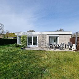 Terrasse des Ferienhauses 'Jubefe' im Bungalowpark 't Hoogelandt, De Dennen, Texel, umgeben von Natur.