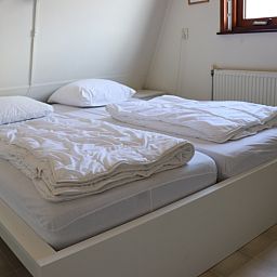 Slaapkamer in Vakantiehuis Gortersmient 330 in De Dennen, Texel met tweepersoonsbed en lichte inrichting.