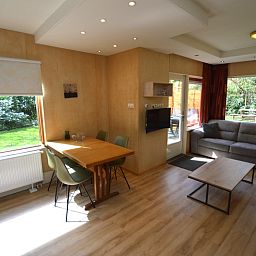 Lichte woonruimte van Vakantiehuis De Nagtegaal 19 in De Dennen Texel met uitzicht op groene tuin.