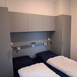 Slaapkamer in Vakantiepark De Bremakker - Bosveld 137, De Dennen, Texel. Comfortabele bedden en moderne inrichting in deze vakantiewoning.