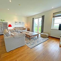 Geraeumiges Interieur des Appartements Bos en Duin 40, De Dennen, Texel mit moderner Einrichtung und viel natuerlichem Licht.