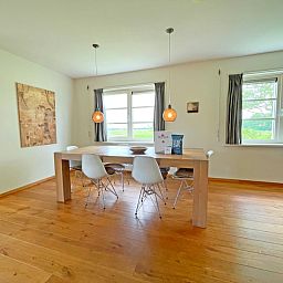Essecke im Appartement Bos en Duin 40, De Dennen, Texel mit grossem Esstisch und Blick ins Freie.