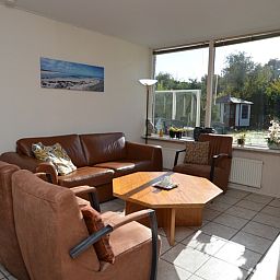 Lichte woonkamer van Vakantiehuis de Parel 222, Texel met uitzicht op de tuin.