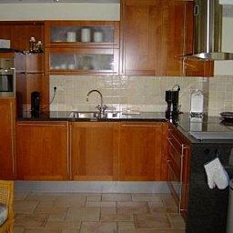 Moderne keuken in Vakantiehuis Gortersmient 356, De Dennen Texel, met houten kasten en roestvrijstalen apparatuur.