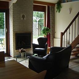 Gezellige woonkamer met open haard in Vakantiehuis Gortersmient 356, De Dennen Texel, met uitzicht op de tuin.