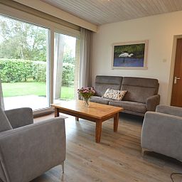 Helle Sitzecke im Ferienhaus Narcis, De Dennen Texel mit Blick auf den Garten.