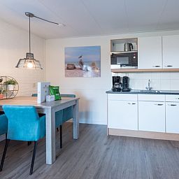 Moderne keuken en eetruimte in Appartement Bos en Duin 12, De Dennen, Texel, volledig uitgerust voor koken.