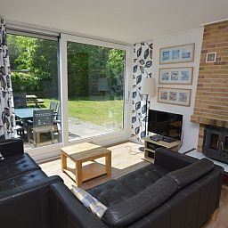 Gezellige woonkamer in Vakantiehuis de Parel 282, De Dennen, Texel met uitzicht op de tuin.