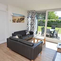 Comfortabele zithoek in Vakantiehuis de Parel 282, De Dennen, Texel met toegang tot het terras.