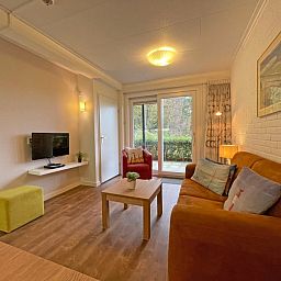 Stijlvolle woonkamer in Appartement Bos en Duin 15, De Dennen, Texel met toegang tot een priveterras.