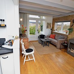 Gemuetliches Wohnzimmer des Ferienhauses Bungalow Uterste Coogh 122 in De Dennen, Texel mit offener Kueche.