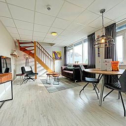 Stilvolle Essecke im Apartment Bos en Duin 25, De Dennen, Texel, mit Holztreppe und bequemen Sitzgelegenheiten.