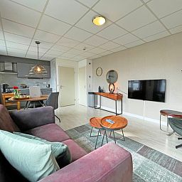 Offene Kueche und Wohnzimmer im Apartment Bos en Duin 25, De Dennen, Texel, mit moderner Ausstattung und gemuetlicher Atmosphaere.