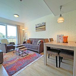 Geraeumige Sitzecke im Apartment Bos en Duin 31, De Dennen, Texel mit moderner Einrichtung und natuerlichem Licht.