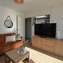 Moderne woonkamer van Bungalow Uterste Coogh 96 in De Dennen, Texel met stijlvolle inrichting en ruime indeling.