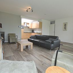 Gemuetlicher Wohnraum im Ferienhaus Tempelierweg 16 - de Brunaire, De Dennen, Texel, mit offener Kueche und grosszuegiger Sitzecke zum Entspannen.