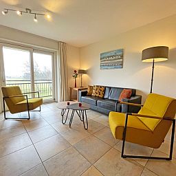 Eethoek in Appartement Bos en Duin 41, De Dennen, Texel met stijlvolle meubels en uitzicht op de natuur.