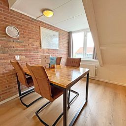 Cozy dining area in Apartment Bos en Duin 34, Texel with a view of the surroundings.
