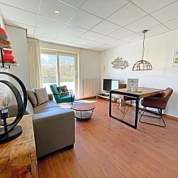 Stijlvolle eet- en woonkamer in Appartement Bos en Duin 18, De Dennen, Texel met toegang tot een zonnig terras.