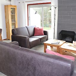 Stilvolles Wohnzimmer des Ferienhauses Gortersmient 252, De Dennen, Texel, mit bequemen Sofas und Kamin.
