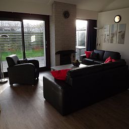 Lichte woonkamer met uitzicht op tuin in Vakantiehuis Gortersmient 210, De Dennen, Texel.