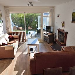 Lichte leefruimte in Vakantiehuis de Parel 200, De Dennen Texel met uitzicht op tuin.