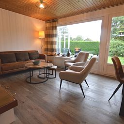 Gemuetliches Wohnzimmer des Ferienhauses de Parel 234 in De Dennen, Texel mit Blick auf den Garten.