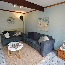 Lichte woonkamer van Bungalow Verste Coogh 56, De Dennen, Texel, met moderne inrichting en sfeervolle verlichting.