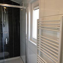 Moderne badkamer in Vakantiepark de Bremakker - Bosveld 103, vakantiehuis in De Dennen, Texel, met luxe douche en handdoekradiator.