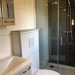 Moderne badkamer in Vakantiepark de Bremakker - Bosveld 103, vakantiehuis in De Dennen, Texel, met stijlvolle douche en wastafel.