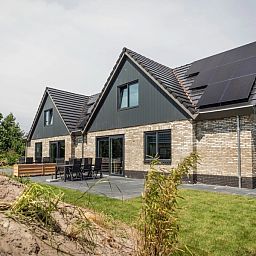 Buitenzijde van Vakantiepark De Koorn-aar Villa in De Dennen Texel met terras en groene omgeving.