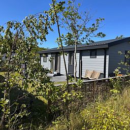 Chalet Wulk im Vakantiepark de Bremakker, gelegen im waldreichen De Dennen auf Texel, mit Sonnenterrasse.