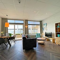 Stilvolle Sitzecke im Apartment Bos en Duin 02, De Dennen, Texel mit bequemem Sofa und dekorativen Elementen.