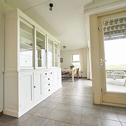 Geraeumiges Esszimmer im Ferienhaus Roodborstje, De Dennen, Texel mit Blick auf die Natur.