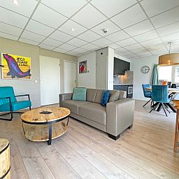 Helles Wohnzimmer der Ferienwohnung Bos en Duin 16 in De Dennen Texel mit gemuetlicher Sitzecke.