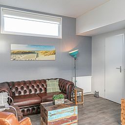 Gezellige woonkamer in Chalet Julie van Vakantiepark de Bremakker, gelegen in De Dennen, Texel. Comfortabel interieur met stranddecoratie.