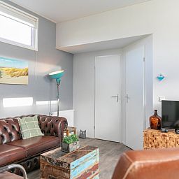 Gezellige woonkamer in Chalet Julie bij Vakantiepark de Bremakker, De Dennen, Texel. Comfortabele zithoek met moderne inrichting.
