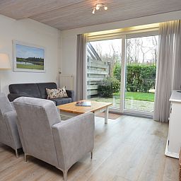 Lichte woonkamer in vakantiehuis Roos, De Dennen, Texel met uitzicht op tuin.