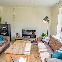 Gemuetliches Wohnzimmer im Ferienhaus 't Hoogelandt 134A, De Dennen, Texel mit bequemer Sitzecke.