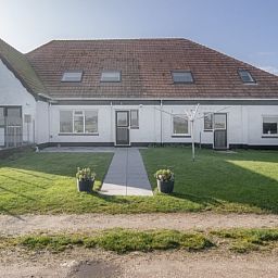Vorderseite des Ferienhauses Hans in De Dennen, Texel mit gruenem Garten.