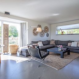 Stijlvolle woonkamer van Villa Serendipity in De Dennen, Texel, vakantiehuis met veel lichtinval.