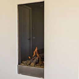 Moderne open haard in Villa Serendipity, vakantiehuis in De Dennen, Texel voor extra sfeer.