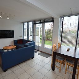 Lichte woonkamer in Vakantiehuis de Parel 244, De Dennen, Texel met comfortabele zithoek en eetgedeelte.