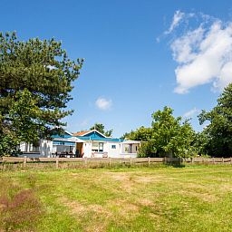 Vacation home Weidezicht in De Dennen, Texel surrounded by nature and trees.