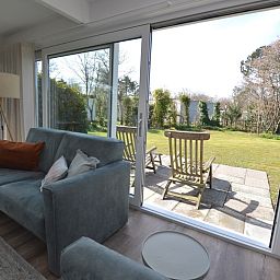 Gezellig terras bij Bungalow Verste Coogh 58 in De Dennen, Texel met uitzicht op groene natuur.